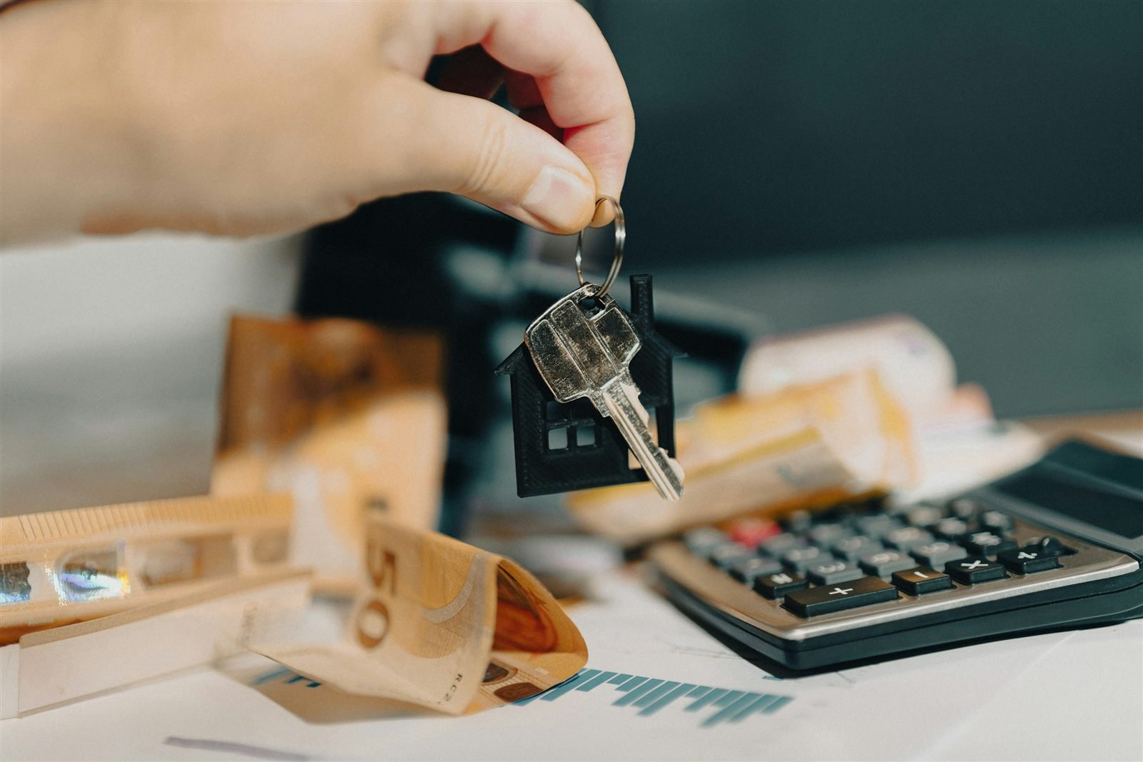 Clé d'un logement au-dessus de billets et d'une calculatrice : rentabiliser sa location